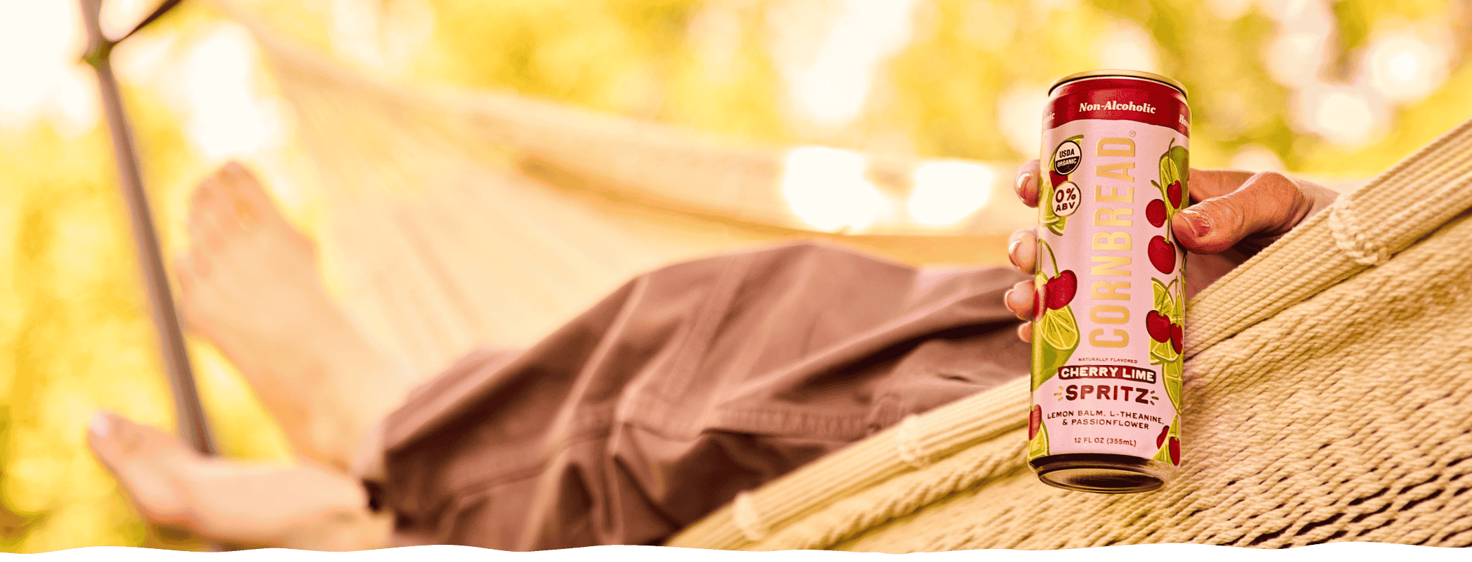 A person relaxing in a hammock with a can of Cornbread Hemp Cherry Lime Social Spritz