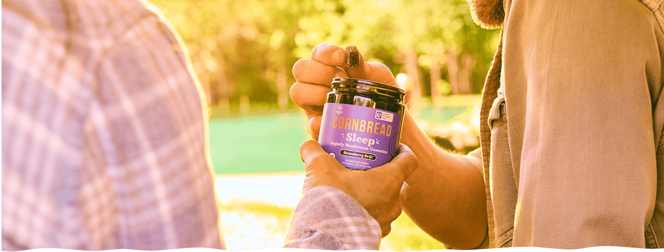 Two people sharing a jar of Cornbread Hemp Mushroom Sleep Gummies