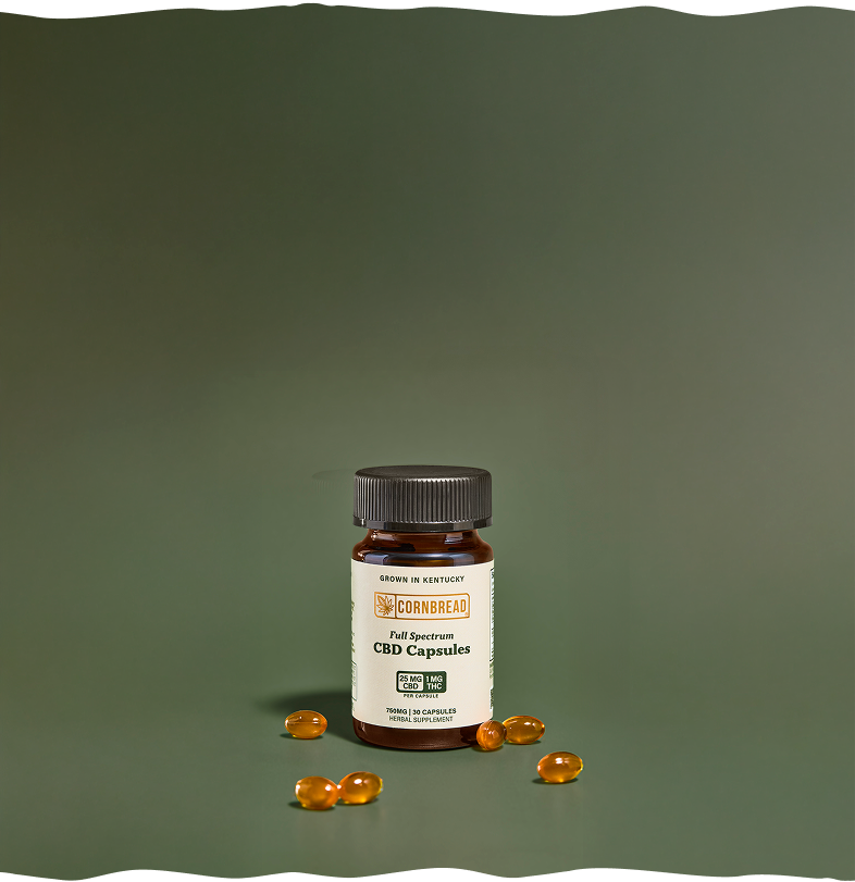 Bottle of Full Spectrum CBD Capsules with capsules on a green background