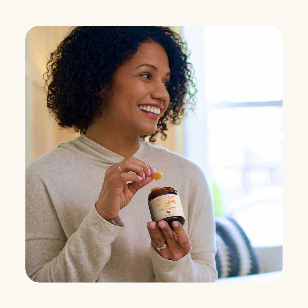 Happy person holds Cornbread Hemp Peach CBD Gummies.